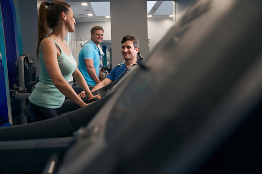 Adult woman and man exercising on cardio machines at gym