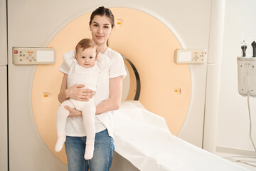 Young woman with child waiting for computed tomography