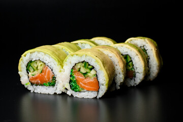 Closeup view of tasty Green dragon sushi rolls with salmon, avocado, cucumber and green caviar