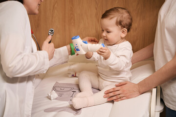 ENT doctor examining child under parental supervision