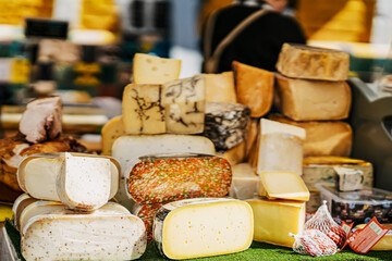 Cheese heads on market counter on market counter. Gastronomic dainty products, real scene, food market