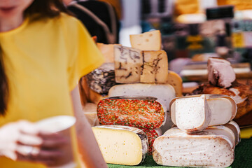 Cheese heads on market counter. Selective focus. Gastronomic dairy produce, real scene, farm food