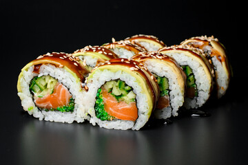Traditional asian rice sushi rolls with salmon, avocado, cucumber and green caviar
