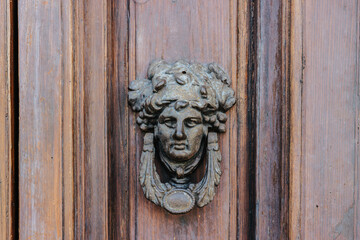 Old face door knocker in Trieste, Italy 