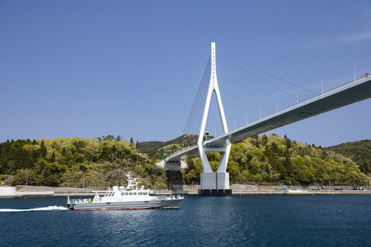 三陸道の秀麗な気仙沼湾横断橋を通過する漁業取締船