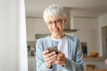 One senior woman with short gray hair use smartphone at home portrait