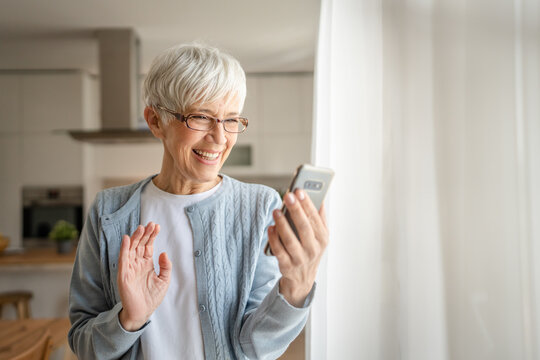 One senior woman with short gray hair use smartphone at home portrait - Powered by Adobe
