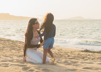 mom and 4 year old daughter on the beach in an idyllic sunset, Shot of a young woman spending time at the beach with her adorable daughter, Mother and daughter holding hands, running jumping on sunny 