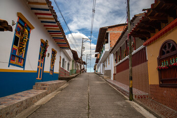 Streets of a town in Colombia, where you can see people walking through colored houses. Town in the mountains of Latin America.