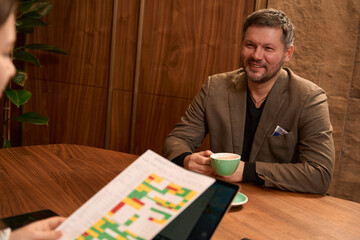 Adult patient drinking coffee at dietitians appointment