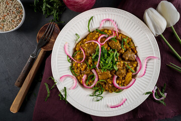 Lamb tajine: Leg of lamb, vegetables, and dried apricots braised in a tajine with a coconut milk/curry sauce. Served with couscous and garnished with pickled red onion and spinach