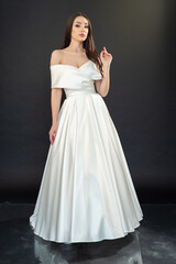 Fototapeta premium Stylish beautiful woman bride in wedding dress on black background