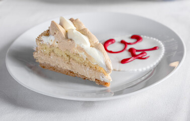 Slice of birthday cake hazelnut taste on white color background and with the Red number 34 as a decoration.