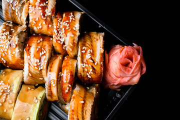 Top view of appetizing sushi rolls with eel, avocado, sesame, vegetables, salmob and cream cheese