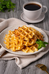 Belgian waffles and coffee on a gray background