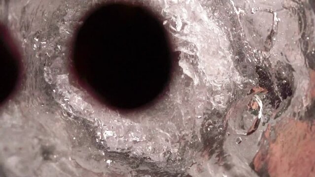 Grapes dropped into a blender with water in slow motion 