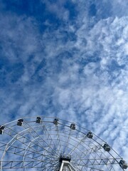 white Ferris wheel construction in the cloudy sky 