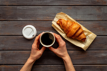 Takeaway coffee in paper cup with croissant. Coffee break background