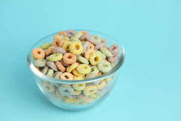Multicolored corn rings for breakfast on a colored background