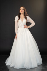 Beautiful fashion bride in wedding dress posing ob black background
