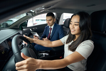 Long-haired asian woman sits in the drivers seat