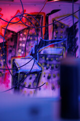 Destroyed building with bright neon lights and dust on walls with spray paint, warehouse with demolished structure covered in messy graffiti art. Old space with fluorescent lights.