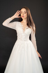 Fototapeta premium Beautiful fashion bride posing in wedding dress on black background 