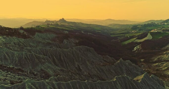 Colorful sunset on the hills of Canossa, below the gullies under the castle of Canossa and in the background the castle of Rossena. Canossa, Reggio Emilia province, Emilia Romagna, Italy, Europe