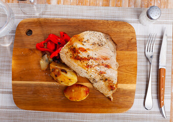 Delicious pork with boiled potatoes and stewed peppers on a plate