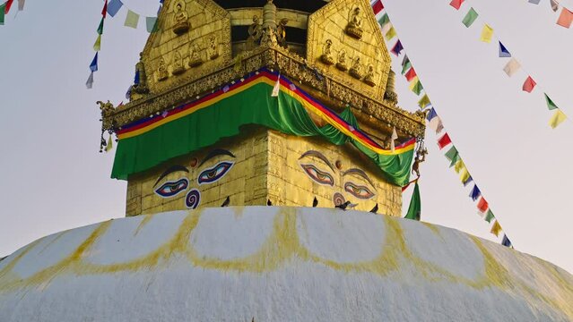 Close-up detail of the Swayambhunath buddha stupa or Monkey temple in kathmandu with buddha eyes and prayer flags during sunrise, Kathmandu, Nepal