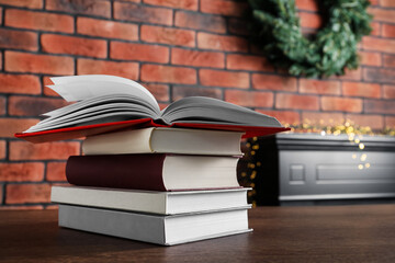 Stack of hardcover books on wooden table indoors
