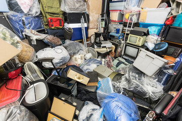 Hoarder house bedroom packed with clothing bags, household objects, vintage electronics and...