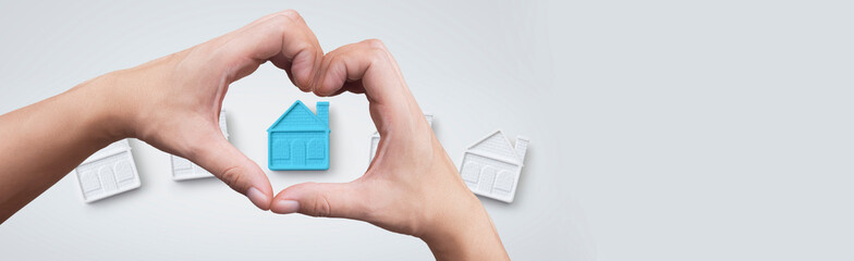 heart shaped hand focusing on a house - concept of real estate purchase and perfect place to live