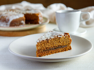 piece of Pryanik, Krasnoarmeysk, traditional ethnic Russian sweet gingerbread made with honey, spices and apple jam, from city of Saratov, covered with sugar icing. On plate with cup of tea