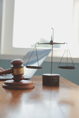 Business and lawyers discussing contract papers with brass scale on desk in office. Law, legal services, advice, justice and law concept picture with film grain effect