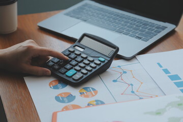 Group of confident business people point to graphs and charts to analyze market data, balance sheet, account, net profit to plan new sales strategies to increase production capacity.
