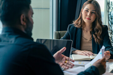 Businessman and businesswoman colleague using laptop and digital tablet working and discussion business plan at office building. Corporate business people partnership and teamwork meeting concept.