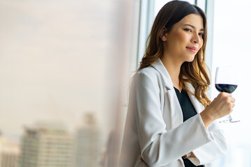 Caucasian businesswoman executive standing by the window at skyscraper office building with...