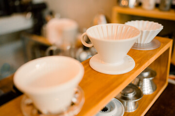 Professional hipster barista making drip brewing, filtered coffee or pour over coffee with hot water and filter paper in coffee shop cafe, black vintage tone of fresh caffeine aroma beverage