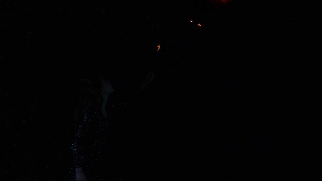 Woman fire breather blowing a fireball in slow motion.