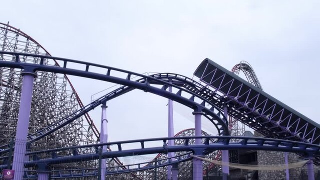 Riding the roller coaster at Energylandia Zator Poland amusement park. Solar powered roller coaster. Rollercoaster against blue sky sunset outdoor leisure family time 