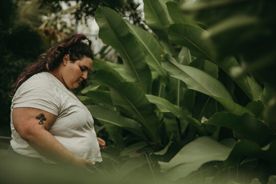 portrait of a plus size jewish woman looking at tropical plants