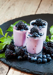 Fototapeta na wymiar Homemade yogurt and milk cocktail with blackberries and blueberries, selective focus