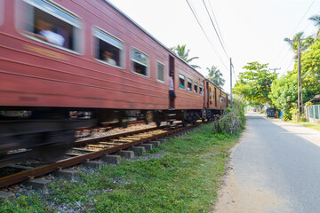 Obraz premium A train passing by a country road in Sri Lanka