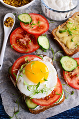 Fototapeta na wymiar Sandwich with cucumber, tomato, egg and watercress on a sheet of paper