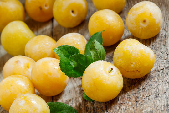 Ripe yellow plums on old wooden background, selective focus