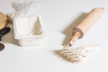 A kitchen tool for making dough. Dough for pizza, the chef rolls out the blanks. Closeup hand of chef baker in uniform white apron cook pizza at kitchen