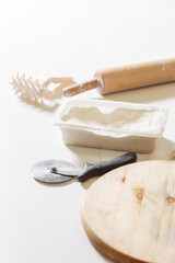 A kitchen tool for making dough. Dough for pizza, the chef rolls out the blanks. Closeup hand of chef baker in uniform white apron cook pizza at kitchen