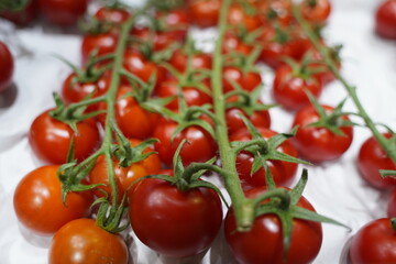 Fresh selected tomatoes in wooden boxes on sale.