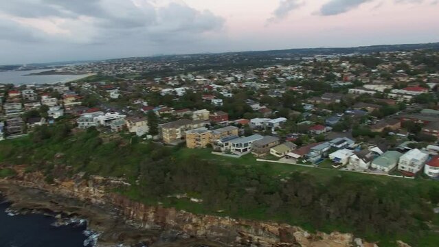 high angle slow pan across the cliffs of Dee Why to Dee Why beach.